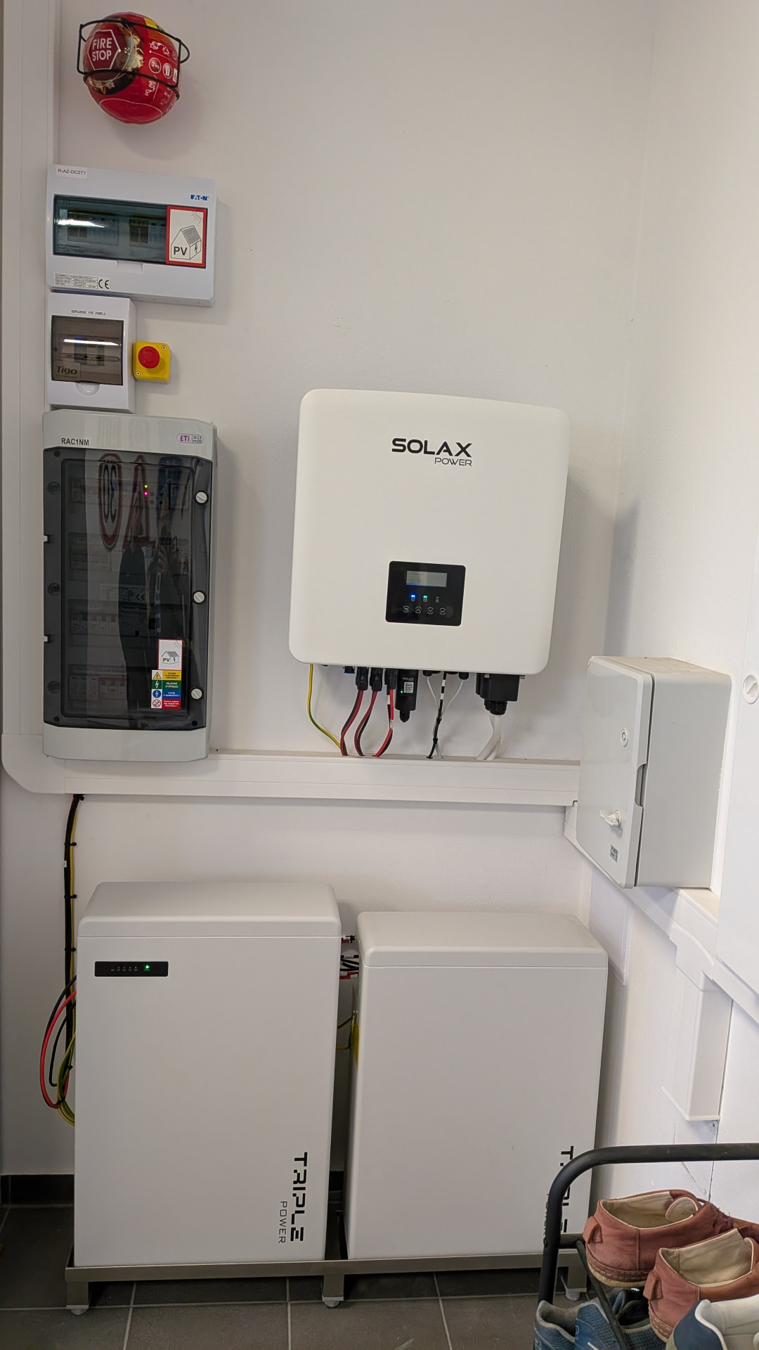 Střídač Solax Power na stěně, dvě bateriové jednotky Triple Power na podstavci a rozvaděče ETI a Eaton v technické místnosti