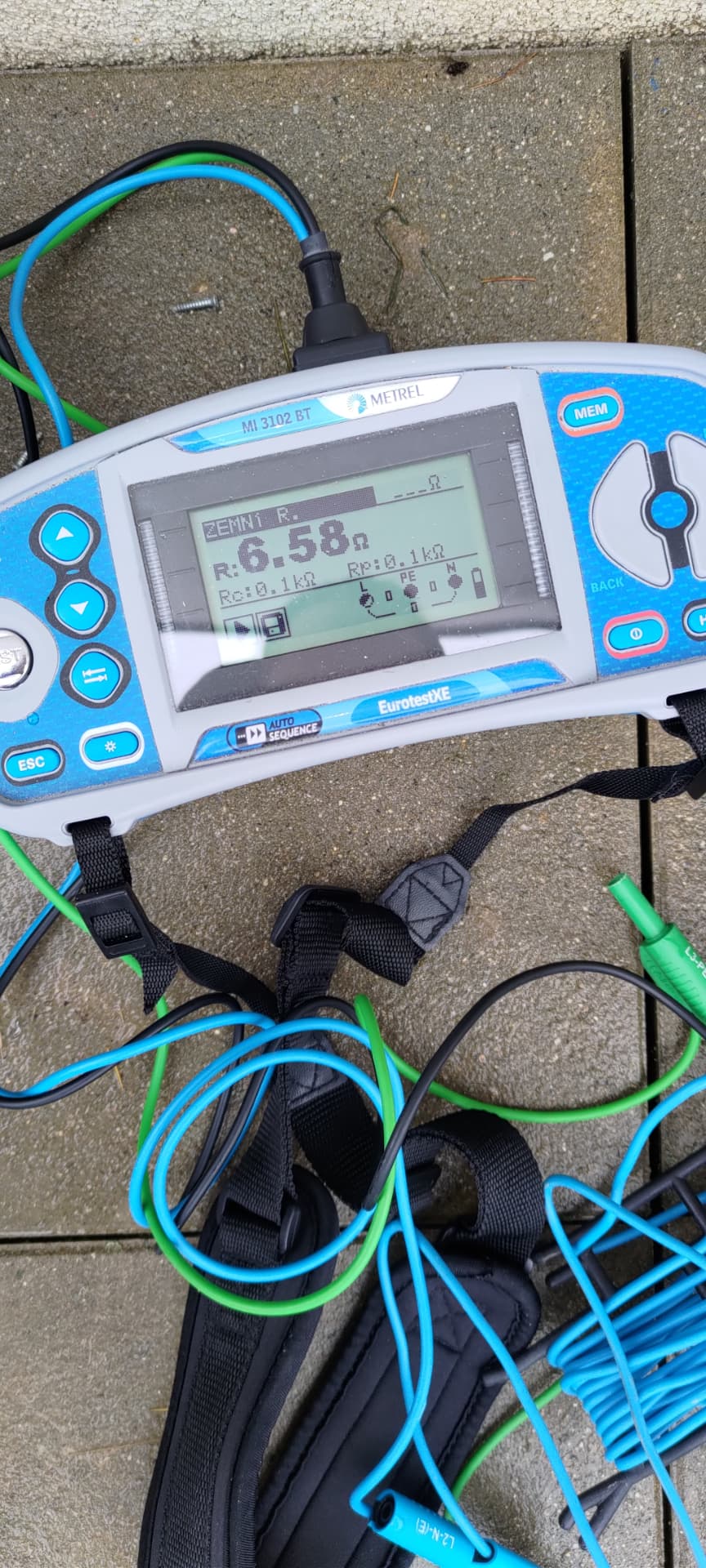 Revizní přístroj Metrel EurotestXE MI 3102 BT s výsledkem měření odporu zemniče 6,58 Ω a rozprostřenými měřicími vodiči
